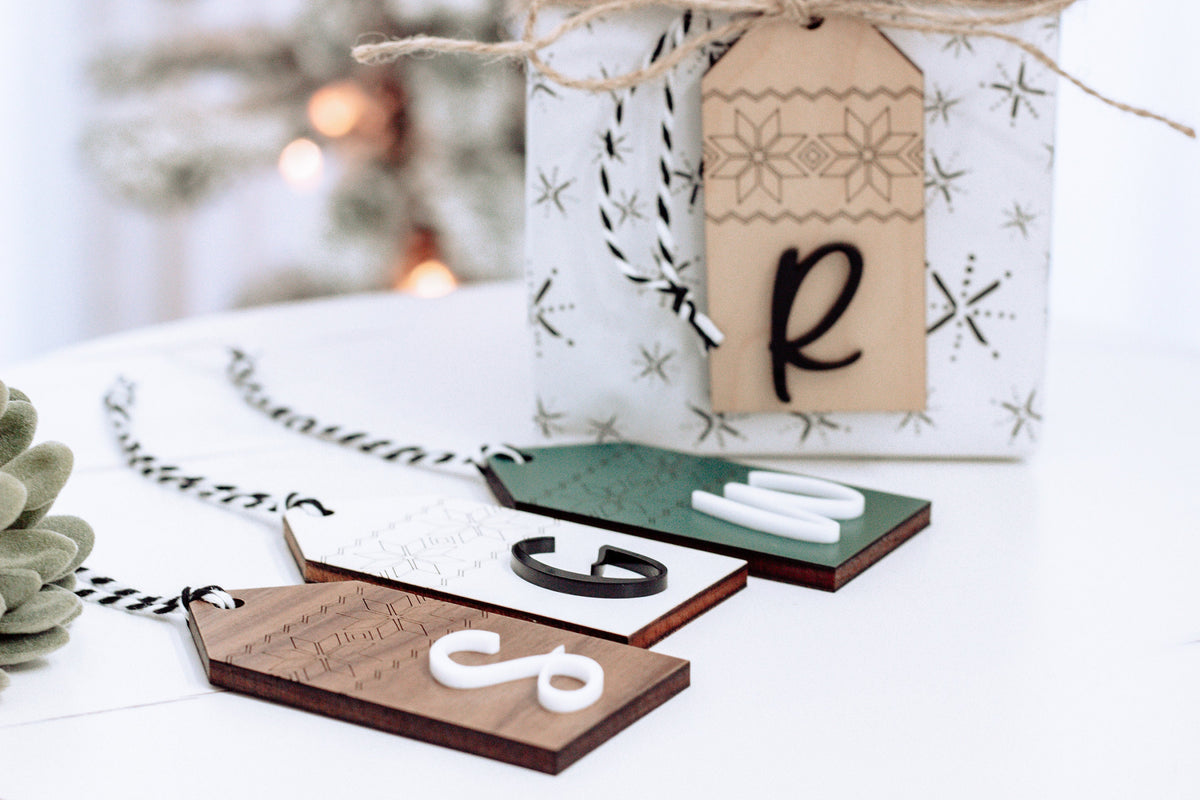 Personalized wood stocking tags with Nordic print and letter R, tied with twine