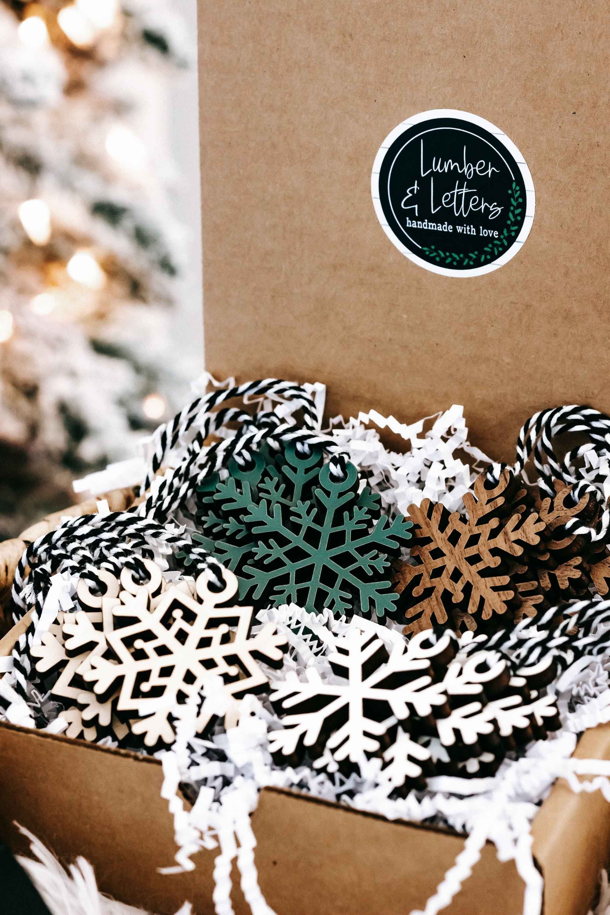 Set of 16 snowflake tree ornaments in a box, white cutouts with green and dark accents