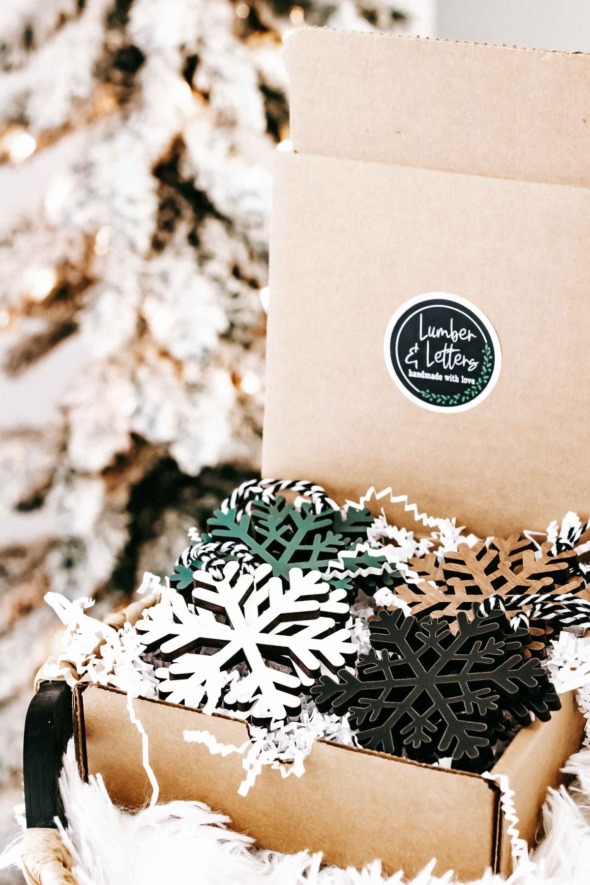 Set of wooden snowflake ornaments in kraft gift box with hanging twine