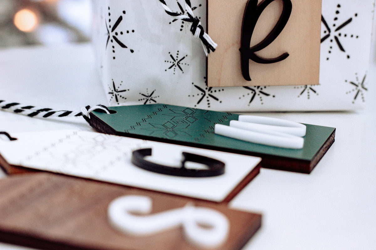 Close-up of personalized wood stocking tags with Nordic pattern and letter 8