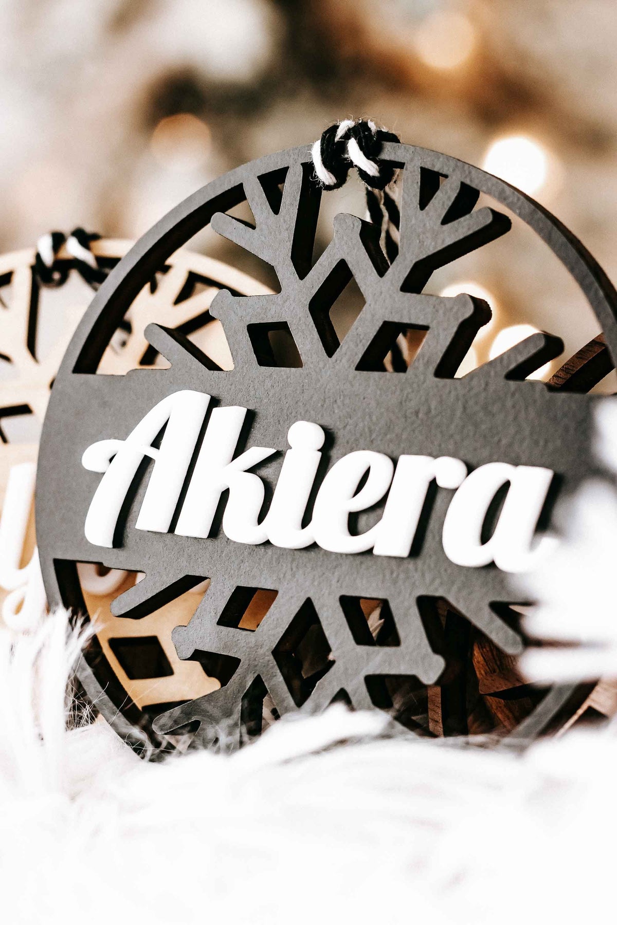 Personalized snowflake ornament with dark gray round backing and white script name