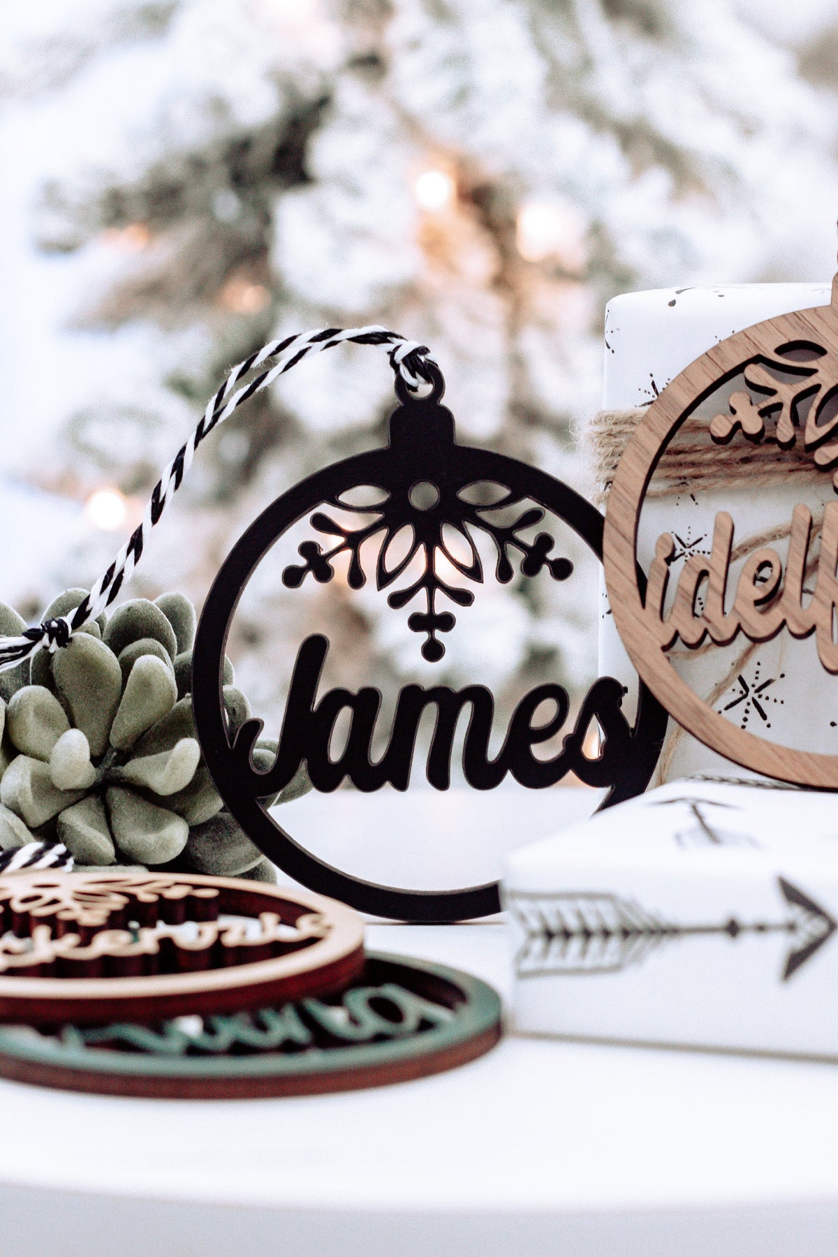 Round personalized name ornament with snowflake engraving, dark text on light wood