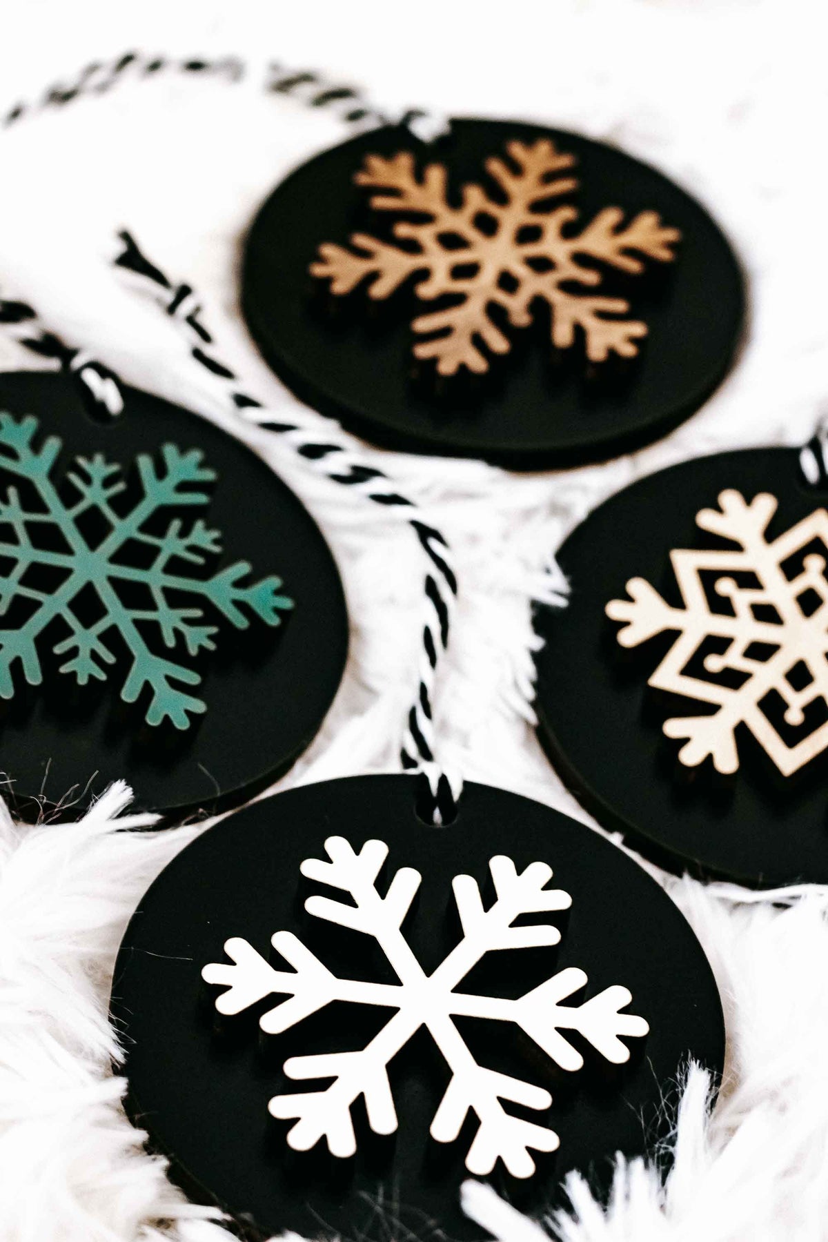 Set of 8 black wooden snowflake ornaments with close-up white snowflake designs