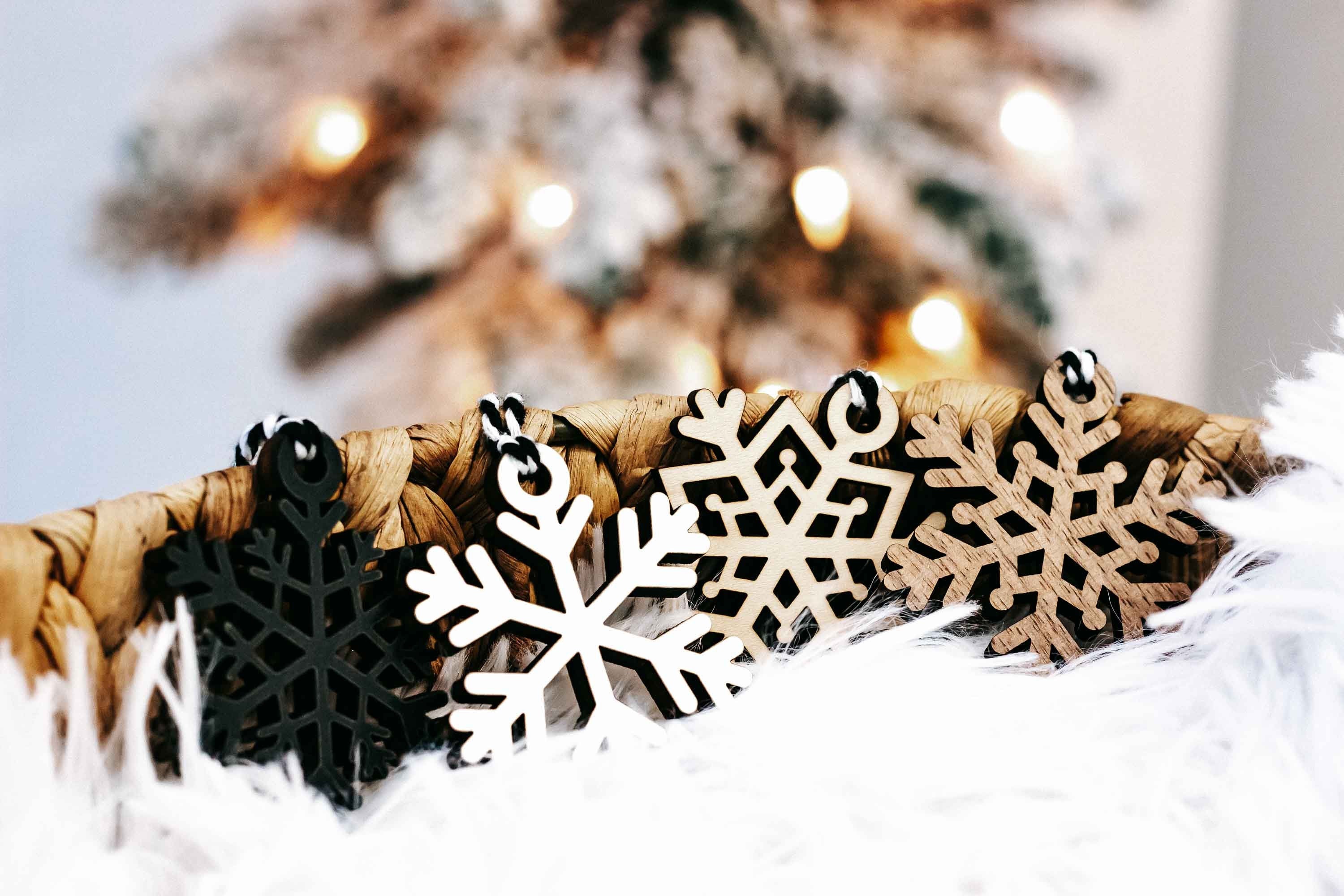 Set of snowflake wooden ornaments with black and white cutouts on twine and white faux fur
