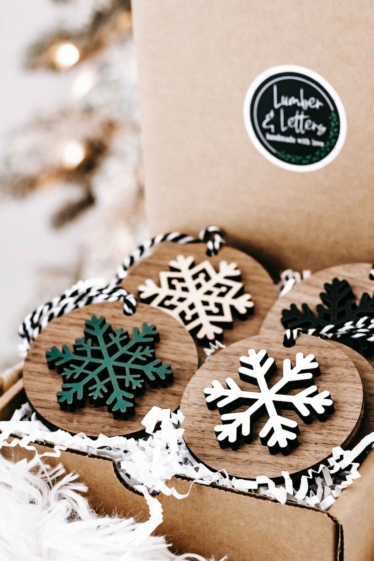 Snowflake and tree wooden Christmas ornaments with striped string hangers on kraft packaging