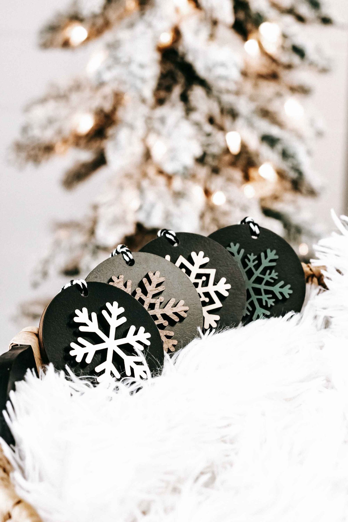 Set of 8 black wooden snowflake ornaments with mixed white snowflake designs