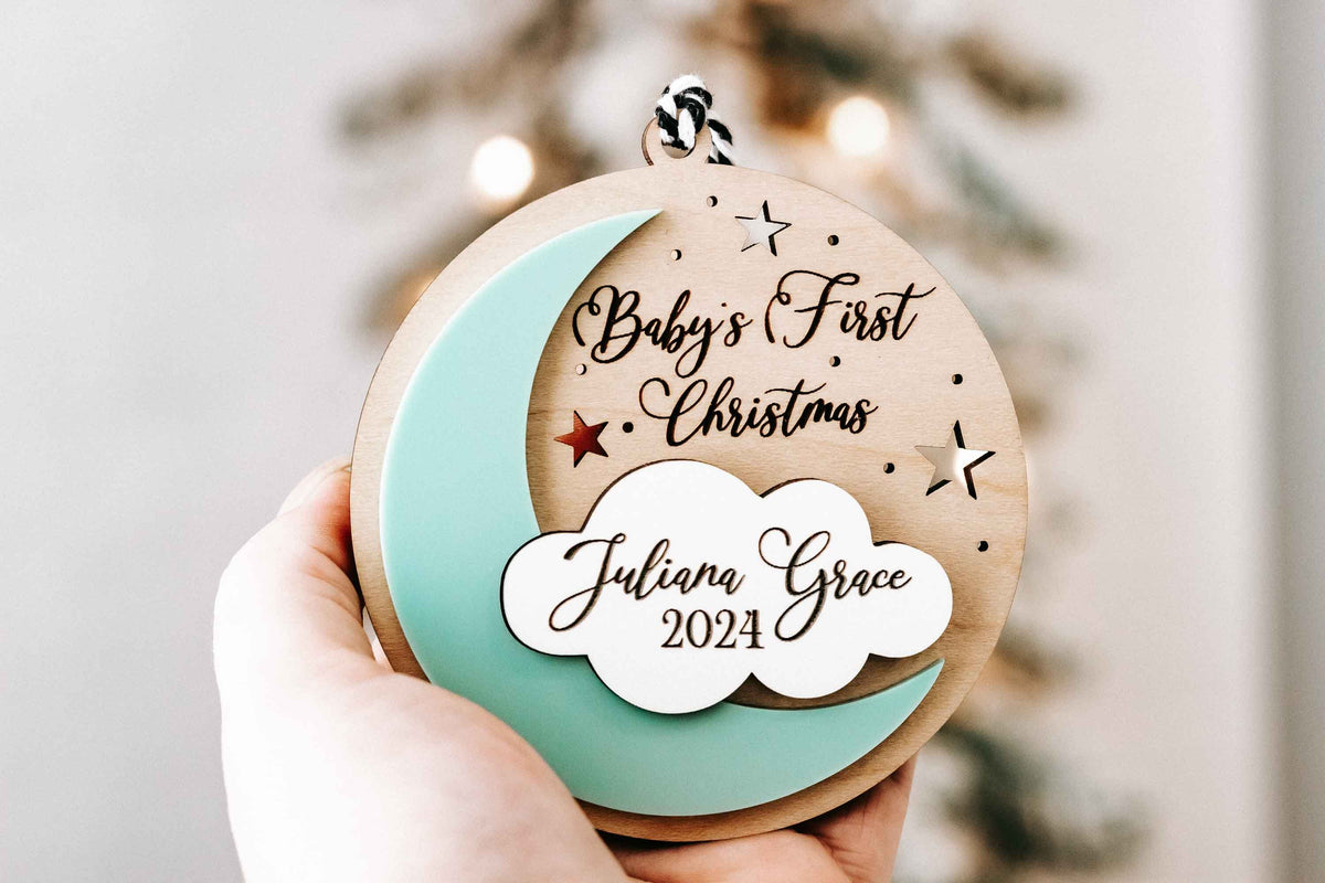 Handheld Personalized Baby’s First Christmas ornament in turquoise with engraved name and 2024