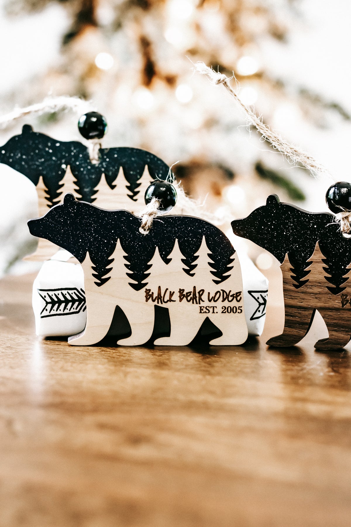 Set of bear cabin ornaments showing dark teal glitter bears and pine tree cabin designs