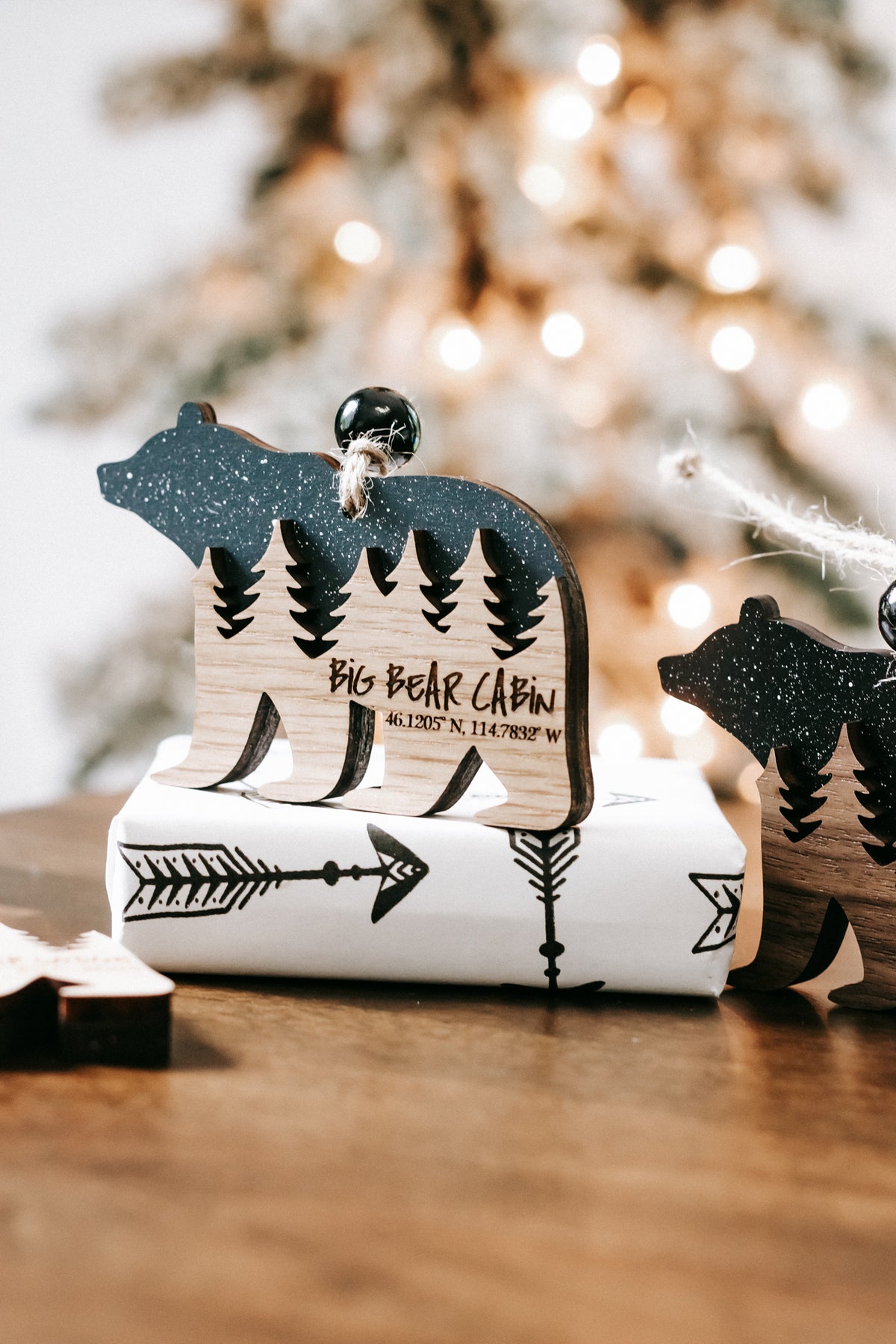 Bear cabin ornament with dark glitter bear, engraved pine trees, and cabin lettering