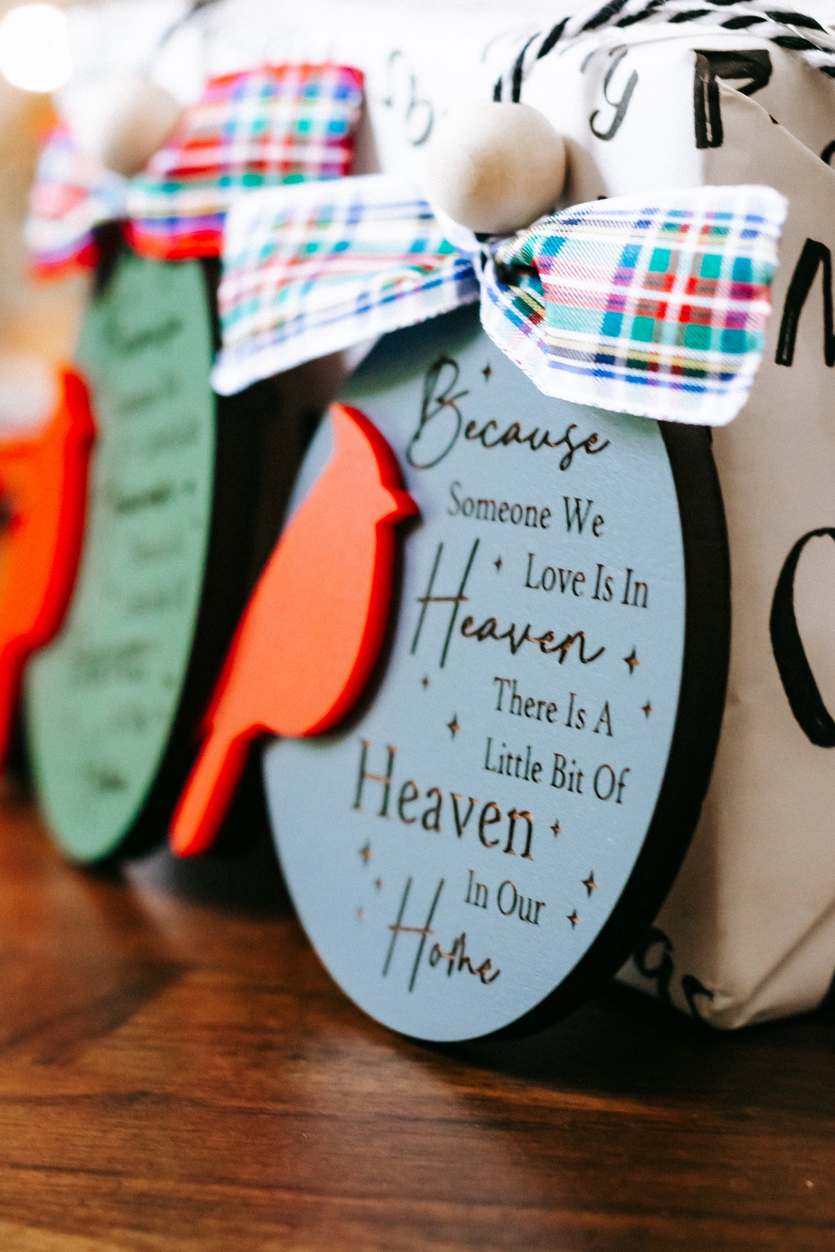 Cardinal memorial ornament with green oval tag, red cardinal cutout, plaid bow, hanging bead