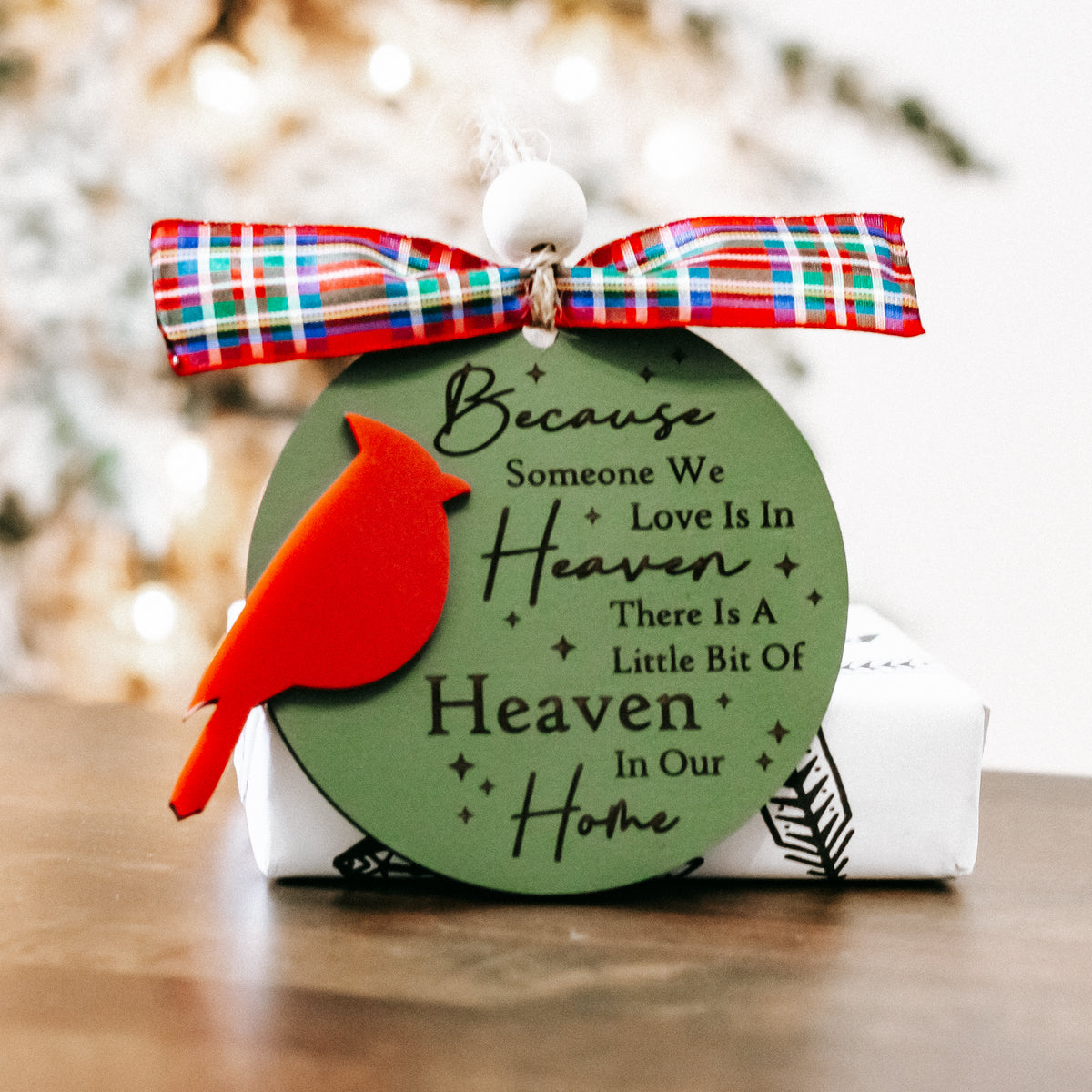 Cardinal memorial ornament with green oval tag, red cardinal, plaid bow, and hanging bead