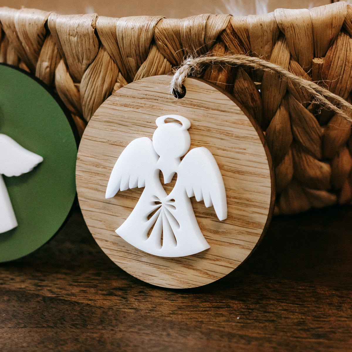 Single round wood angel ornament with white winged figure and twine loop for hanging
