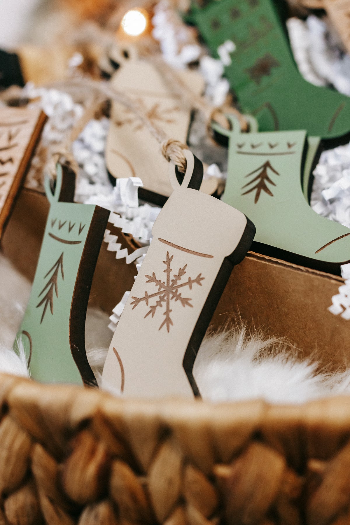 Engraved wooden stocking ornaments on string with green and cream panels and etched designs