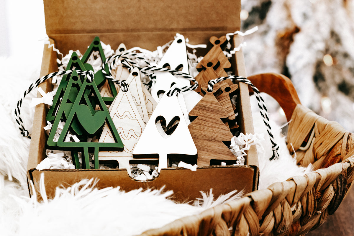 Wooden Christmas ornament box with green tree, white triangle, and heart designs, twine hangers