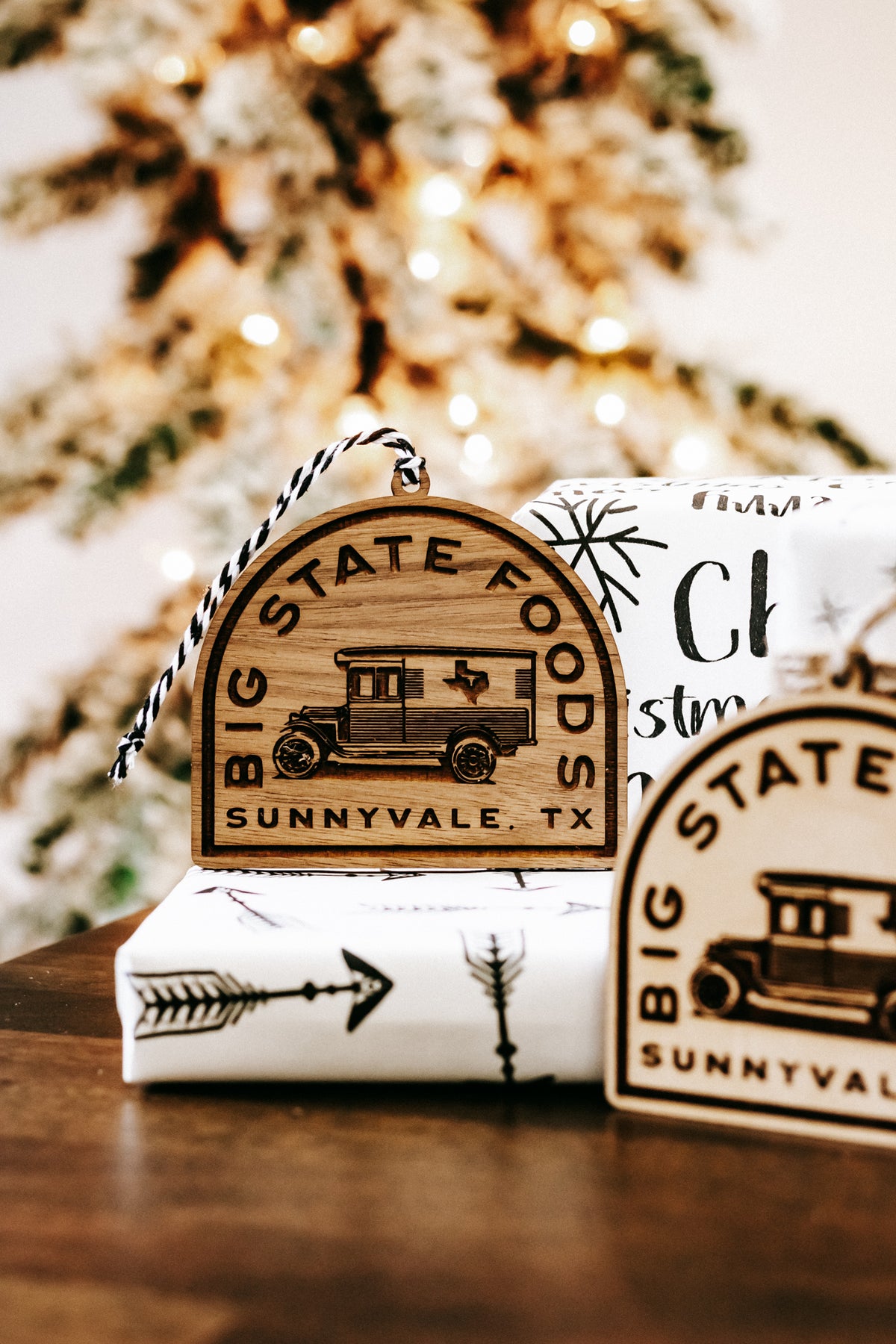 Wooden hanging ornament set with van logo tags and ribbon ties on a tabletop.