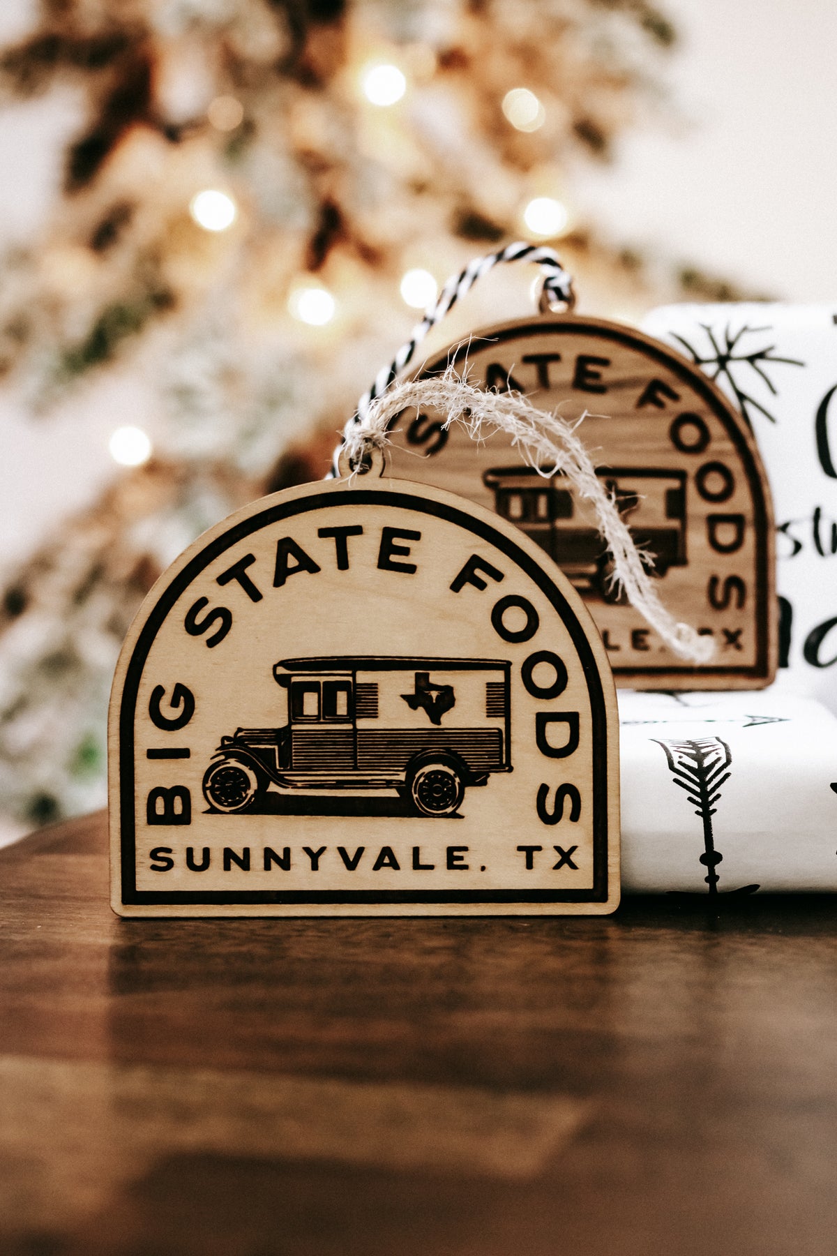 Wooden hanging ornament with van illustration and “Big State Foods, Sunnyvale, TX”.