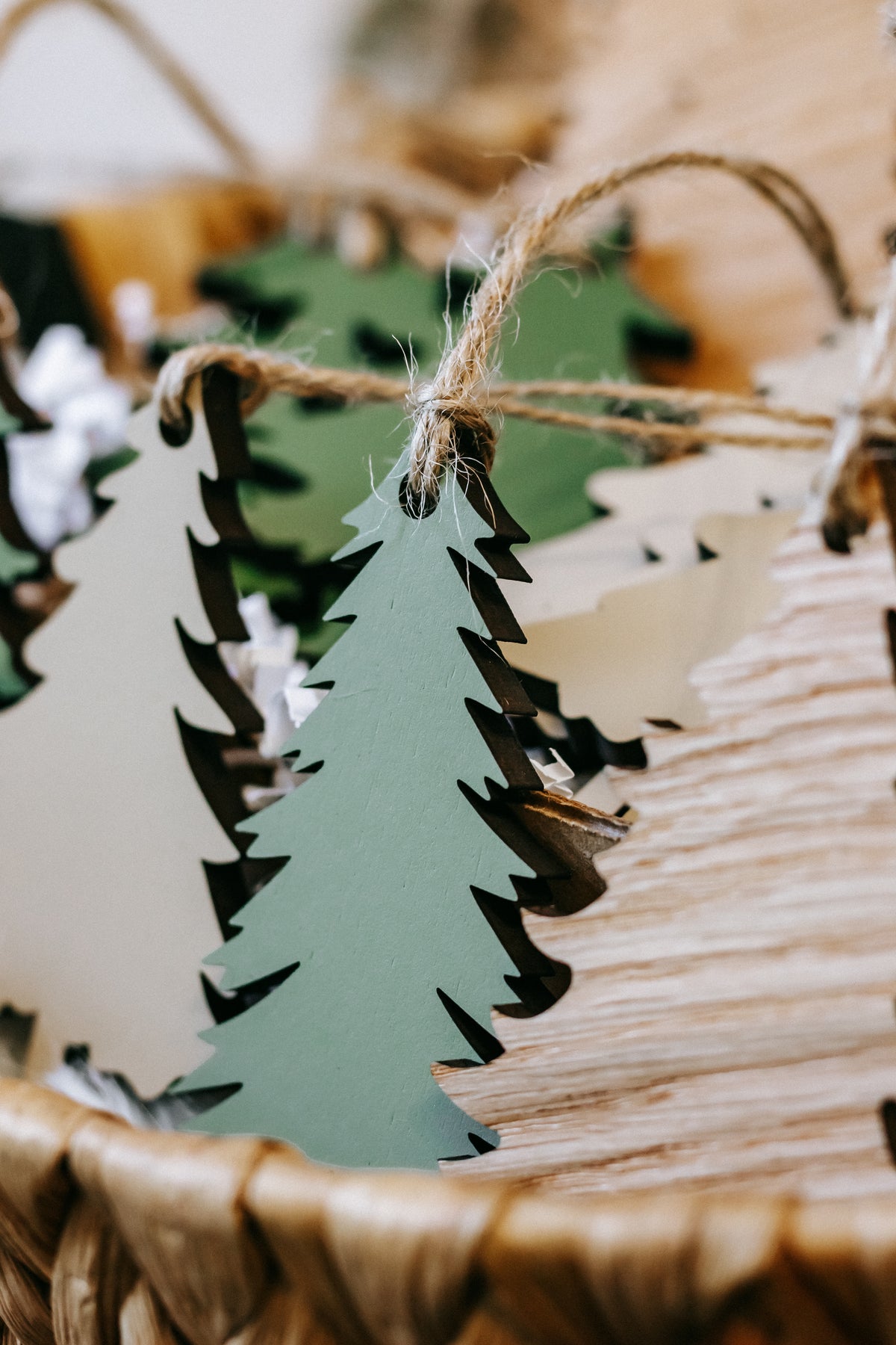 Close-up of painted wooden Christmas tree ornament in dark green with hanging twine