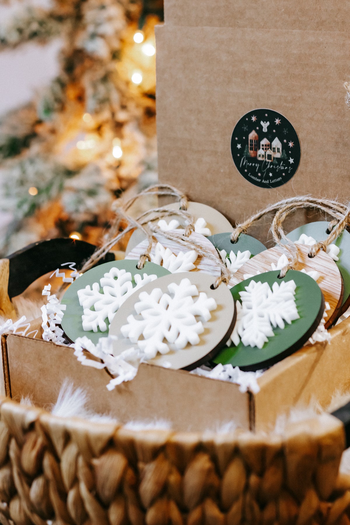 Handmade style round wooden snowflake ornaments in green and wood, white cutouts, twine hangers