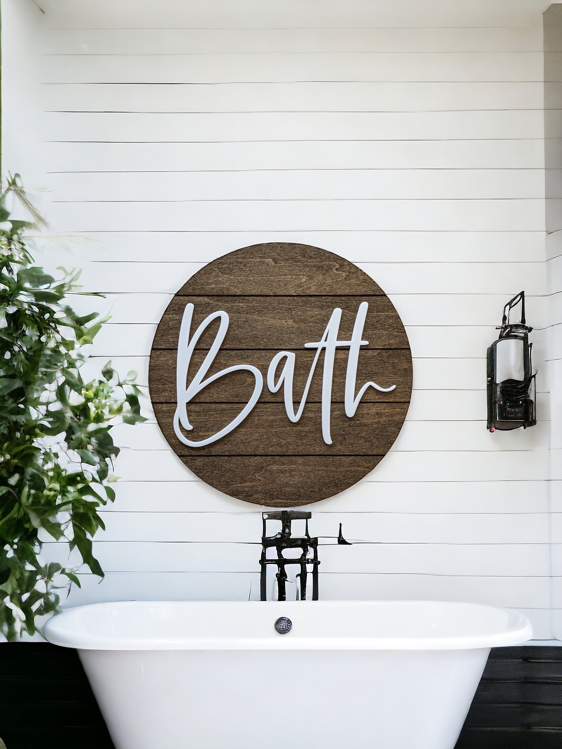 Round wooden bath wall sign with white “Bath” lettering above a bathtub