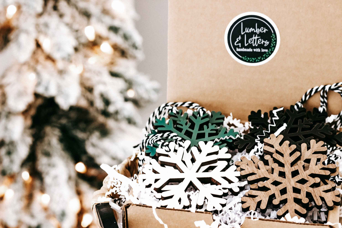 Wooden snowflake ornament set with dark, natural wood, and white accents, close-up