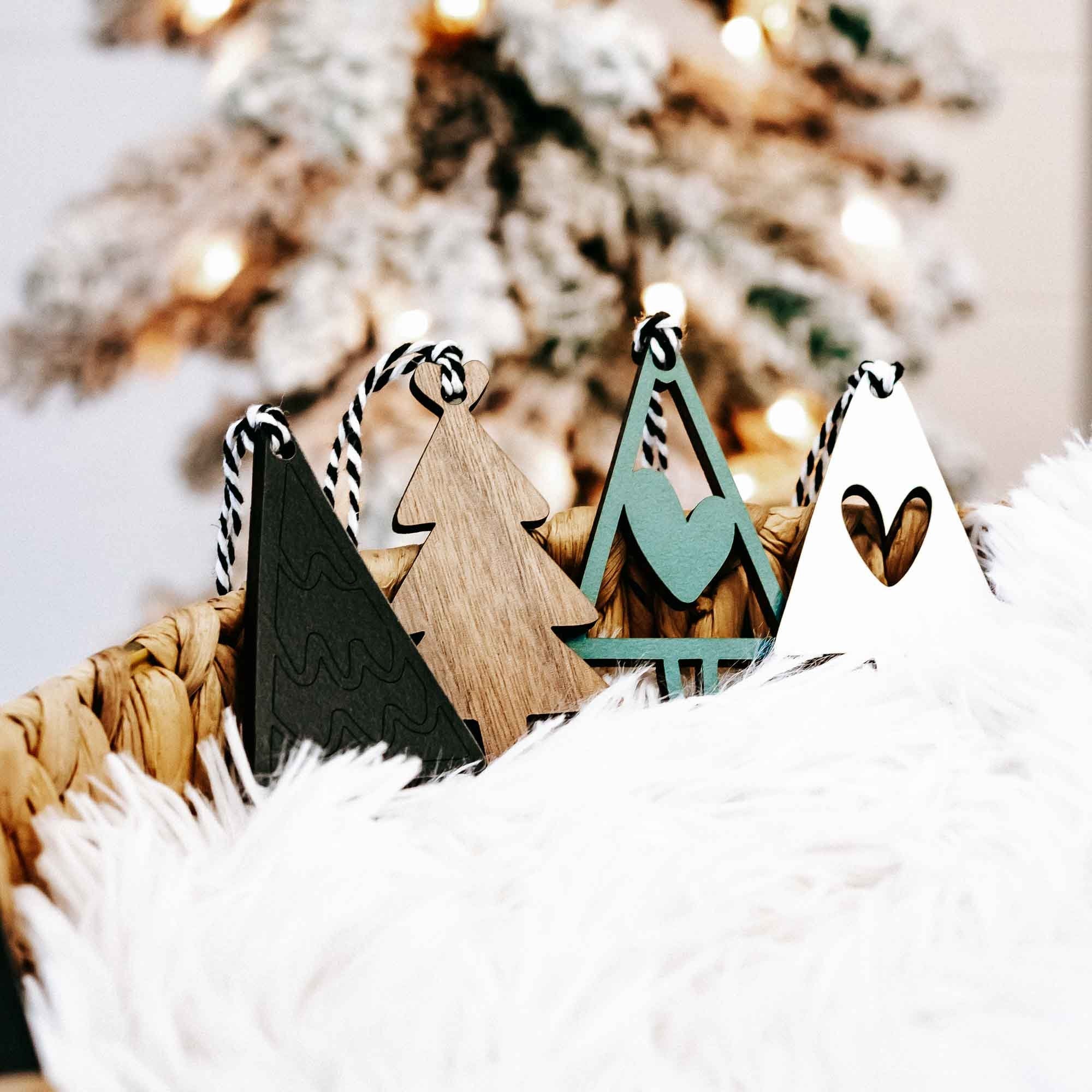 Assorted wooden Christmas tree ornaments with striped rope hangers in natural wood and dark green