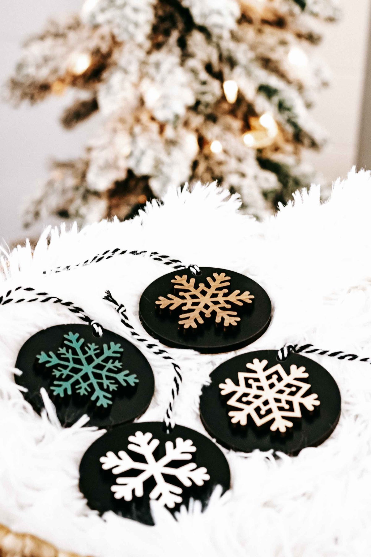 Set of 8 black wooden snowflake ornaments in white faux-fur with multicolor snowflakes