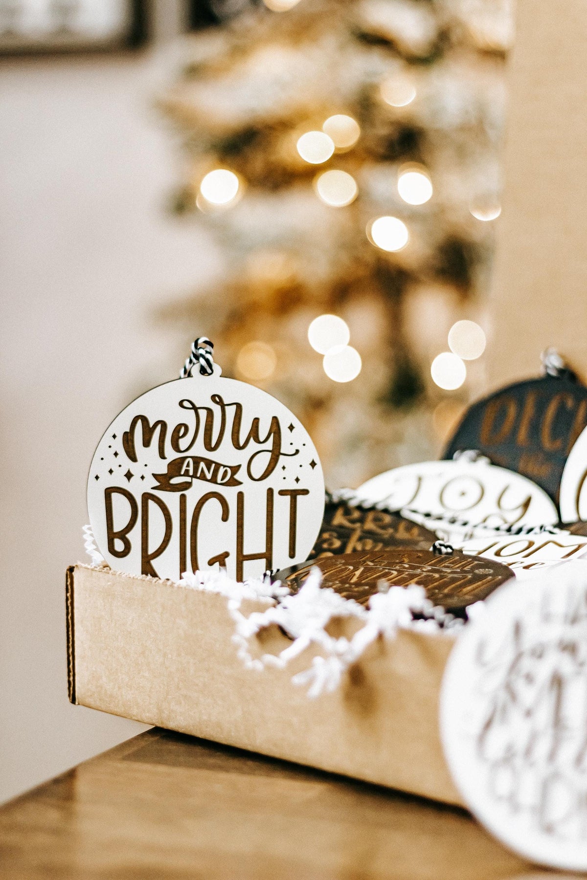 Merry Christmas engraved ornament with a top hanger, black and white text in a gift box.