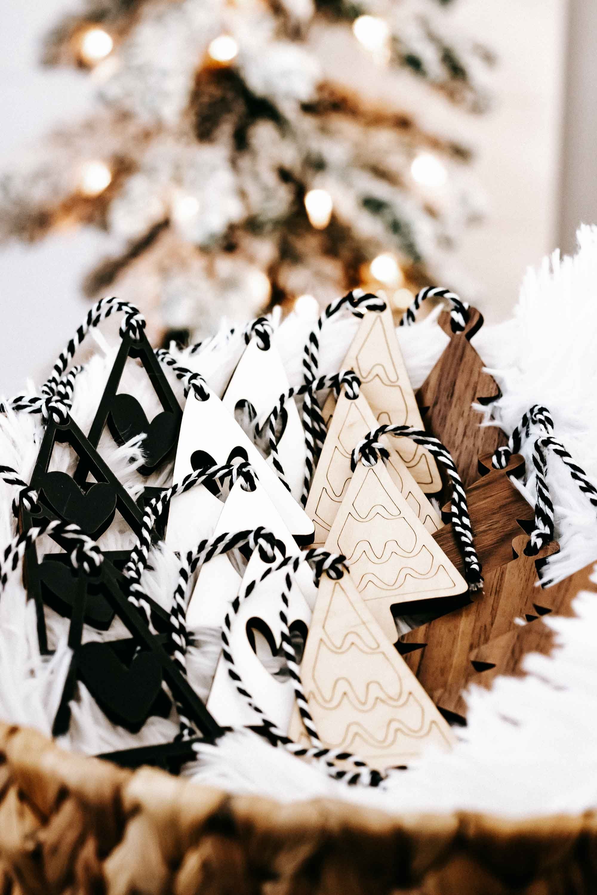 Assorted boho Christmas tree ornaments in black, white, and wood with striped rope hangers