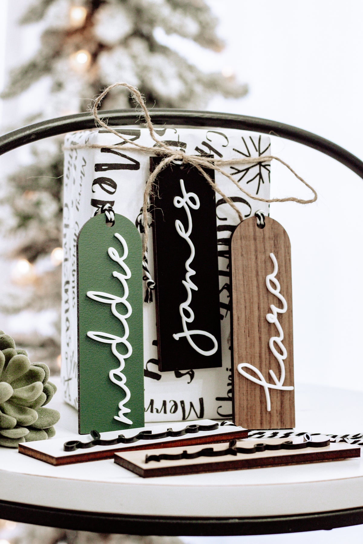 Hanging personalized stocking tags with black, green, and brown lettering