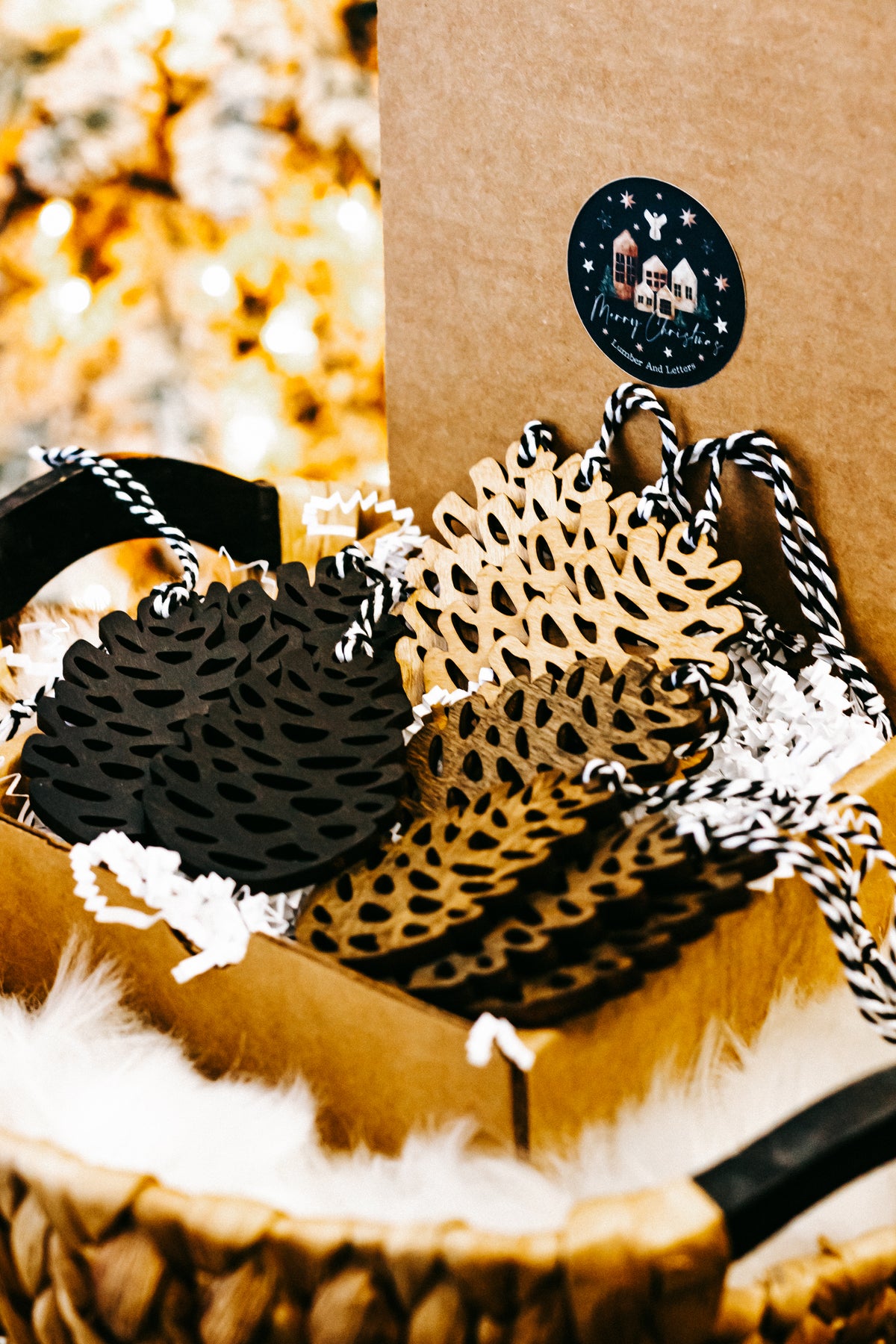 Hand-stained wooden pinecone ornaments with striped twine hangers in black, amber, and natural