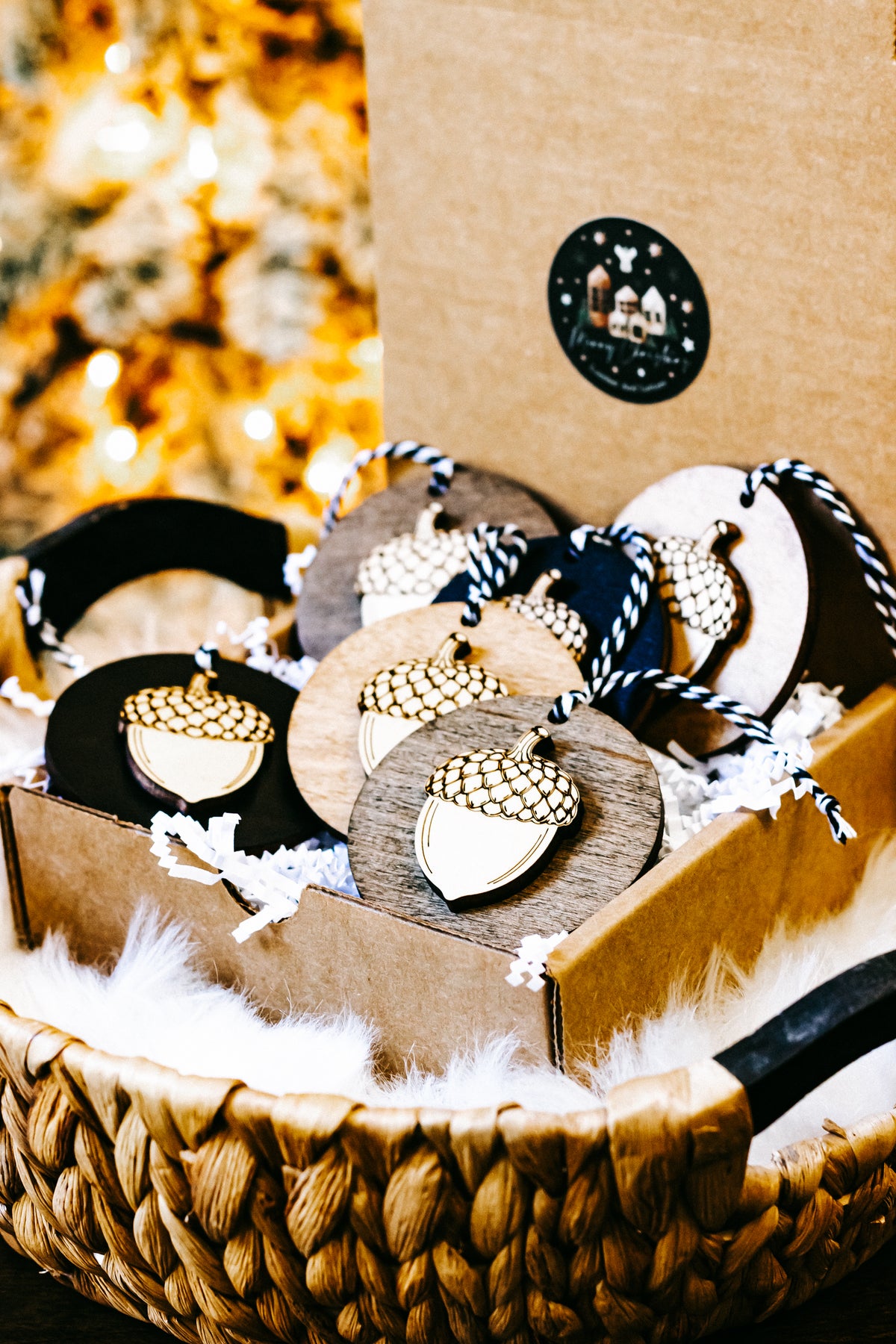 Assorted round acorn ornaments with gold checkered caps on wood and black discs, twine ties.