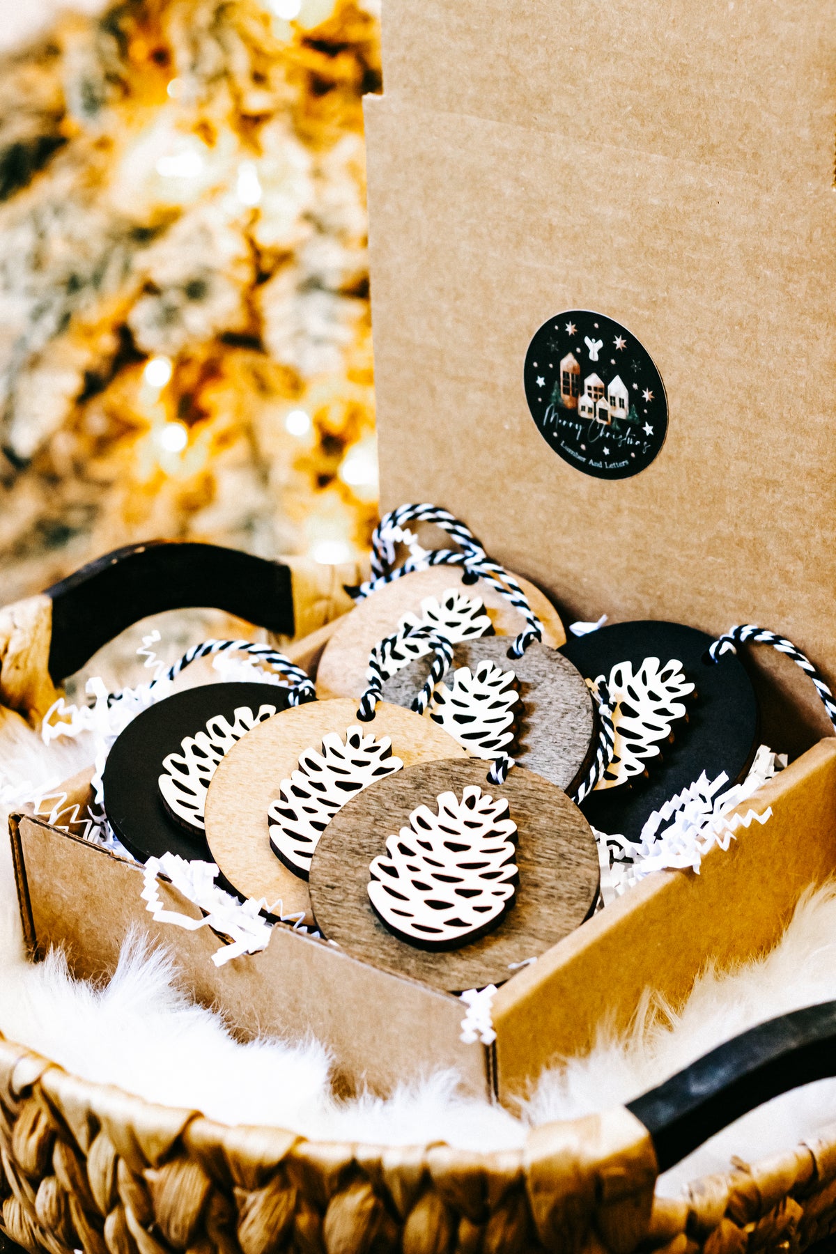 Wooden pinecone ornaments in a gift box, round black and wood discs with twine loops