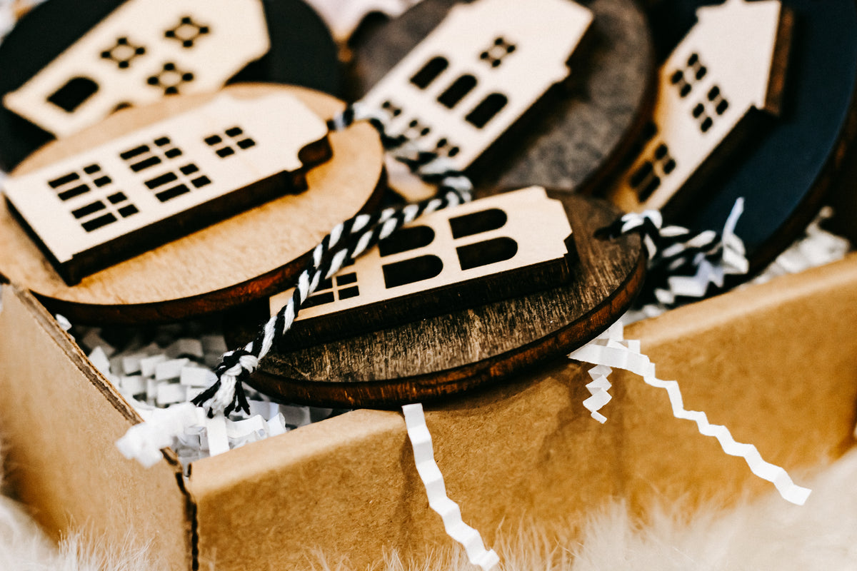 Close-up of layered round house ornaments with white filler and striped twine cords