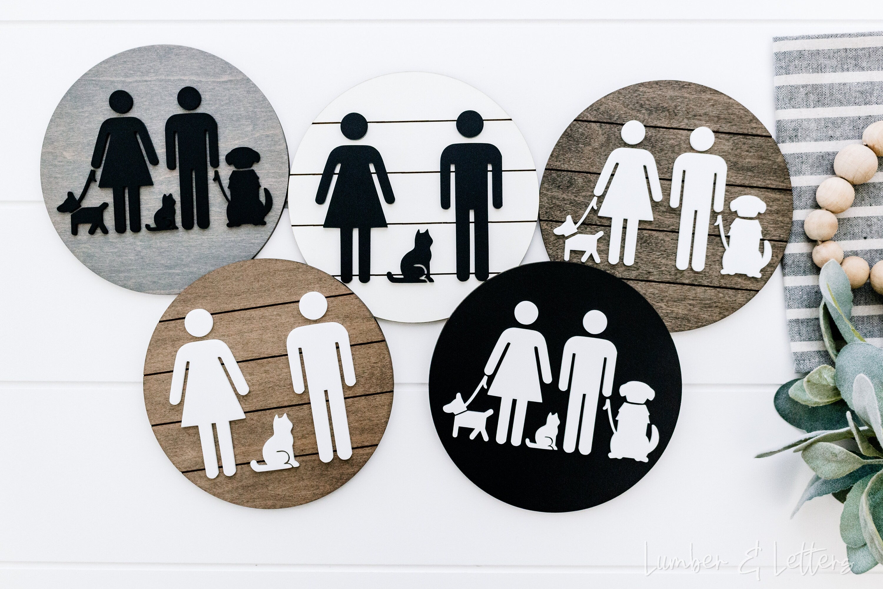 Set of round restroom signs with pet silhouettes in dark, tan, white, and black circles