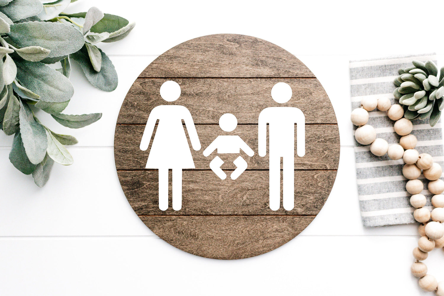 3D restroom changing room sign, round dark wood with white male, female and baby icons