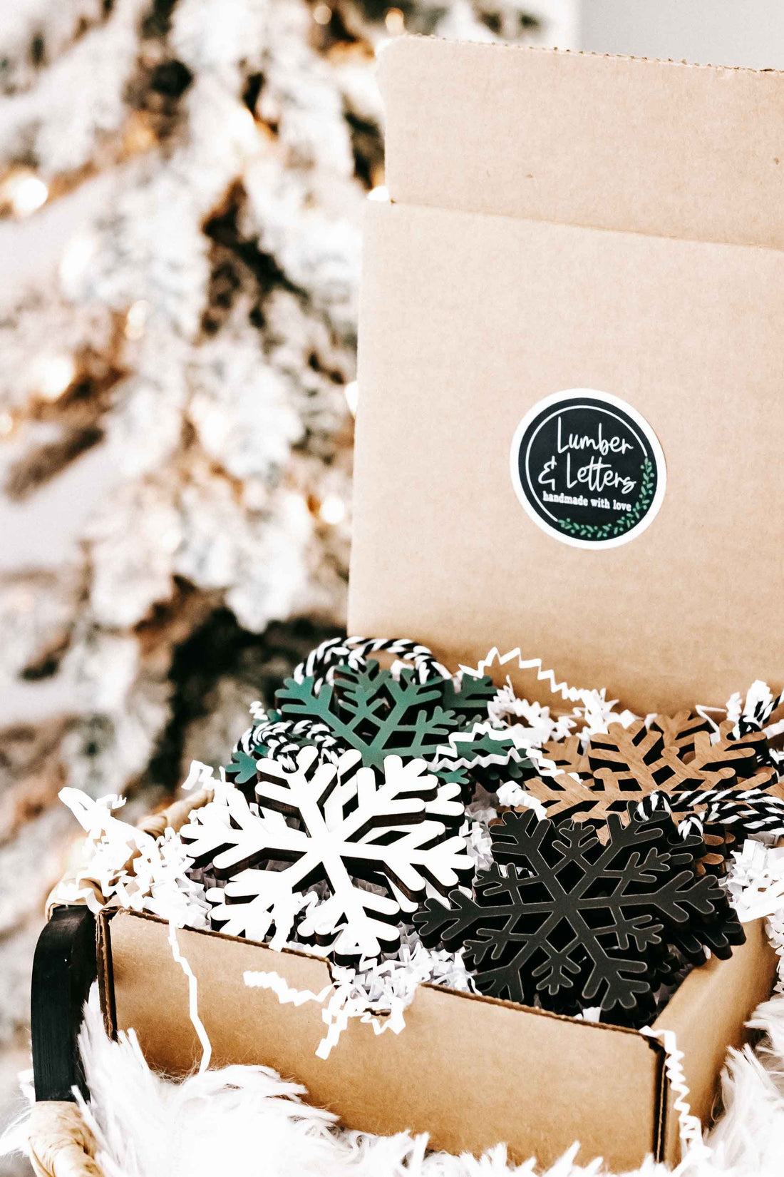 Set of wooden snowflake ornaments in kraft gift box with hanging twine