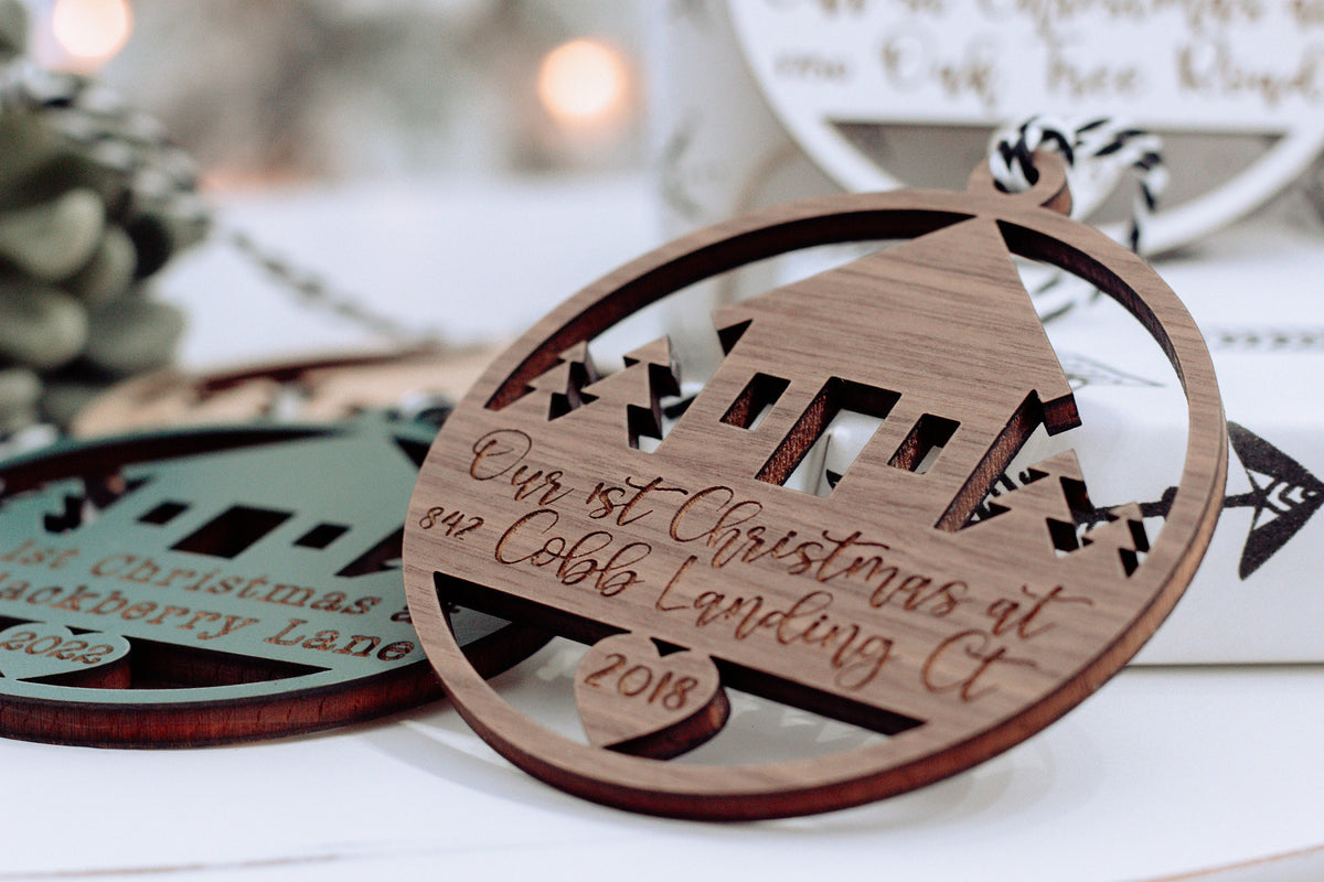 Round wooden Christmas keepsake ornament with laser-cut village and cursive date text