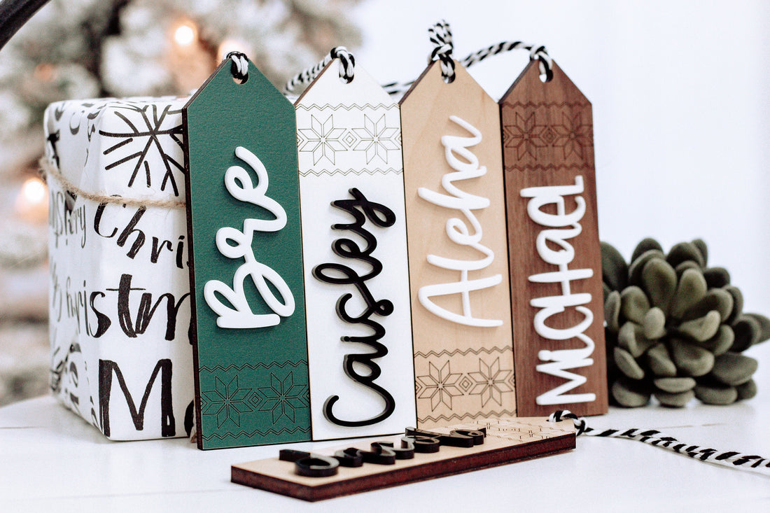 Set of five wooden personalized stocking tags with Scandinavian patterns and twine hangers.