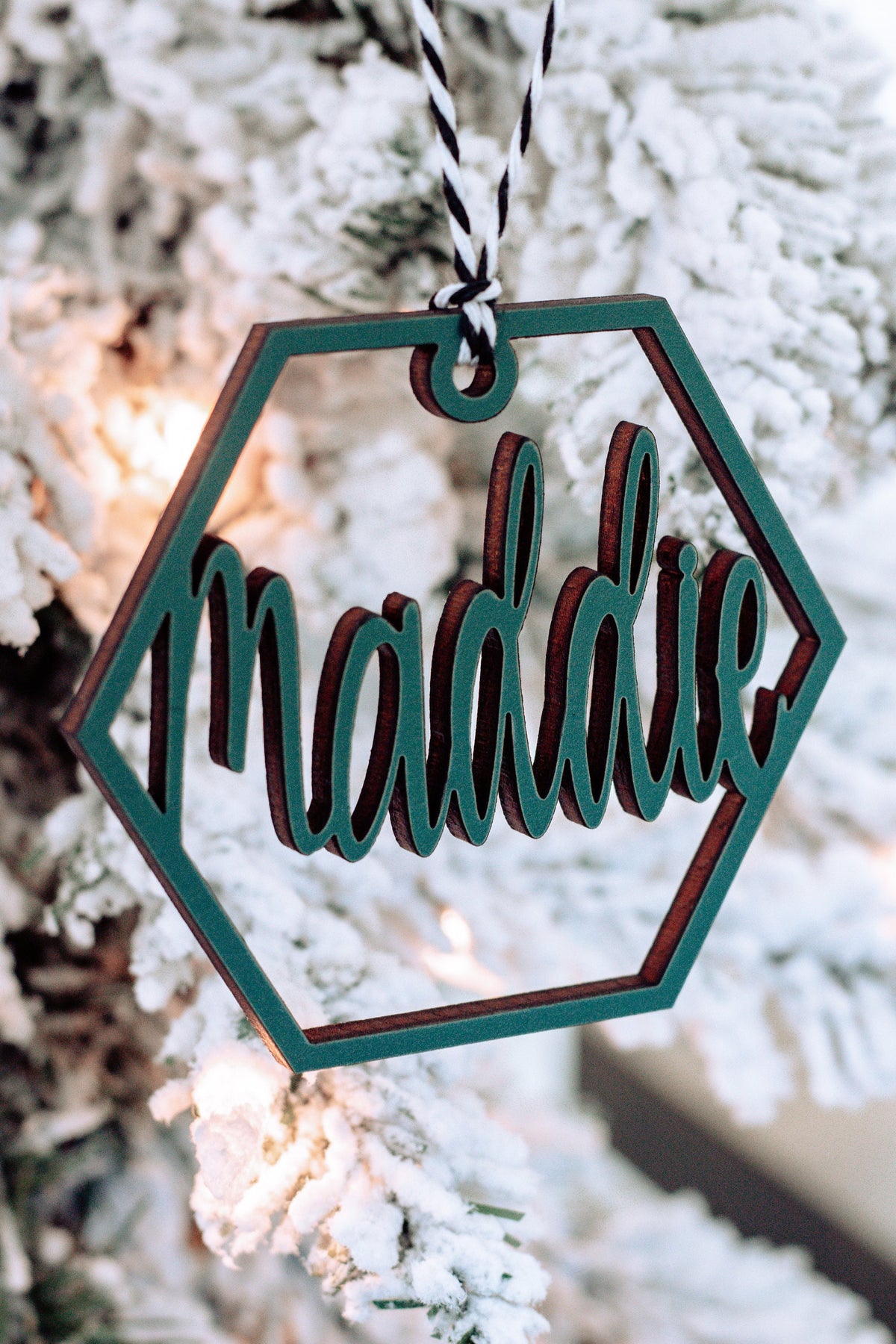 Wooden hex name ornament with teal cursive “Madalie” engraving, twine loop