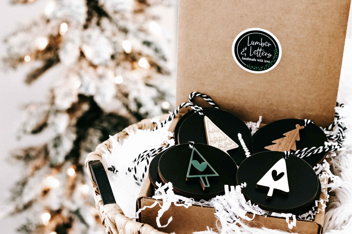 Kraft gift bag with black and wood Christmas ornaments on twine strings