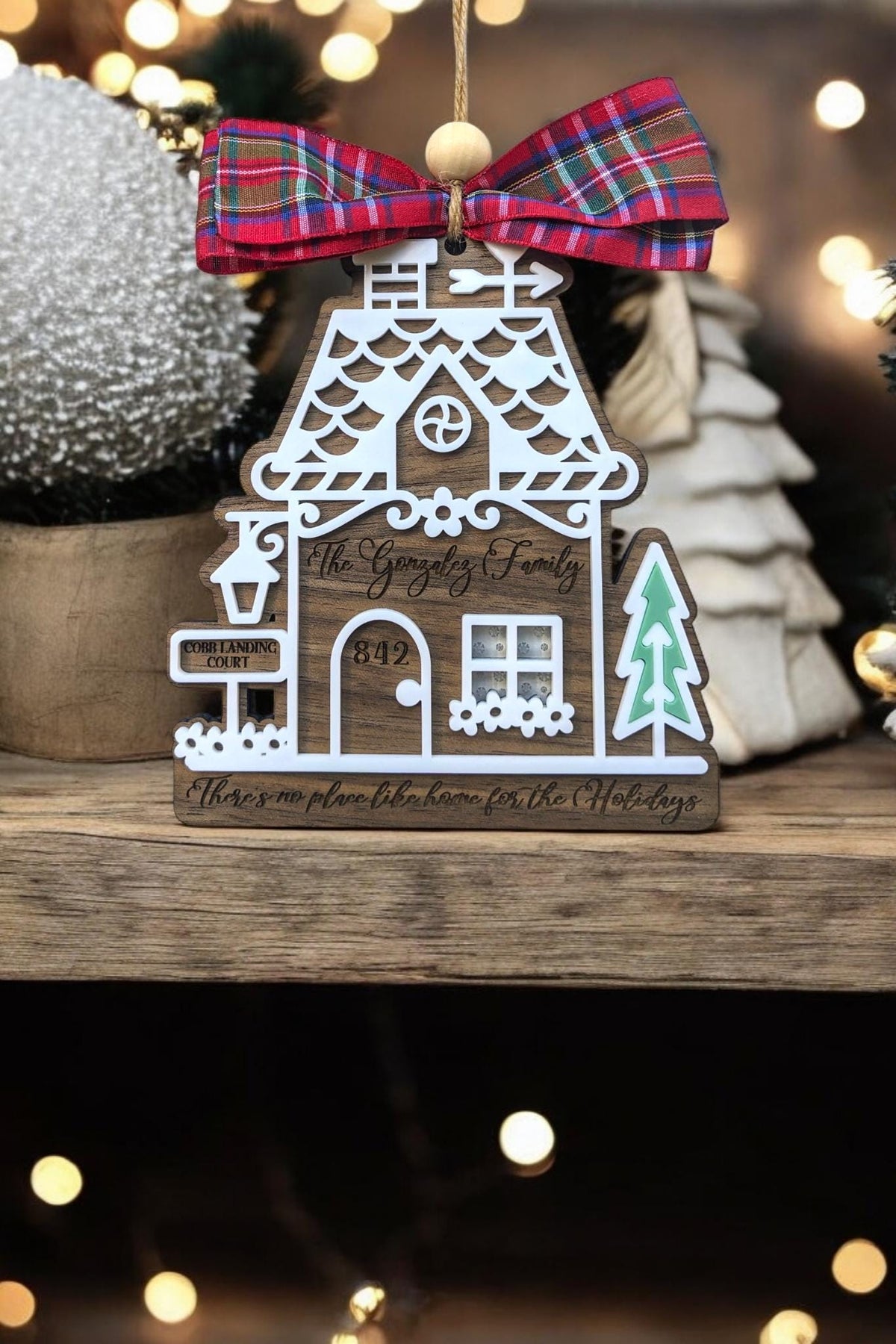 Wood gingerbread house ornament with red plaid bow, “842,” mailbox, and teal tree cutout