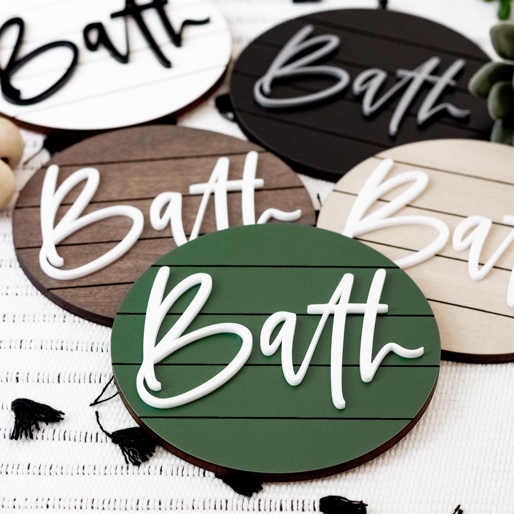 Set of round bath signs with “Bath” script in white, black, and green