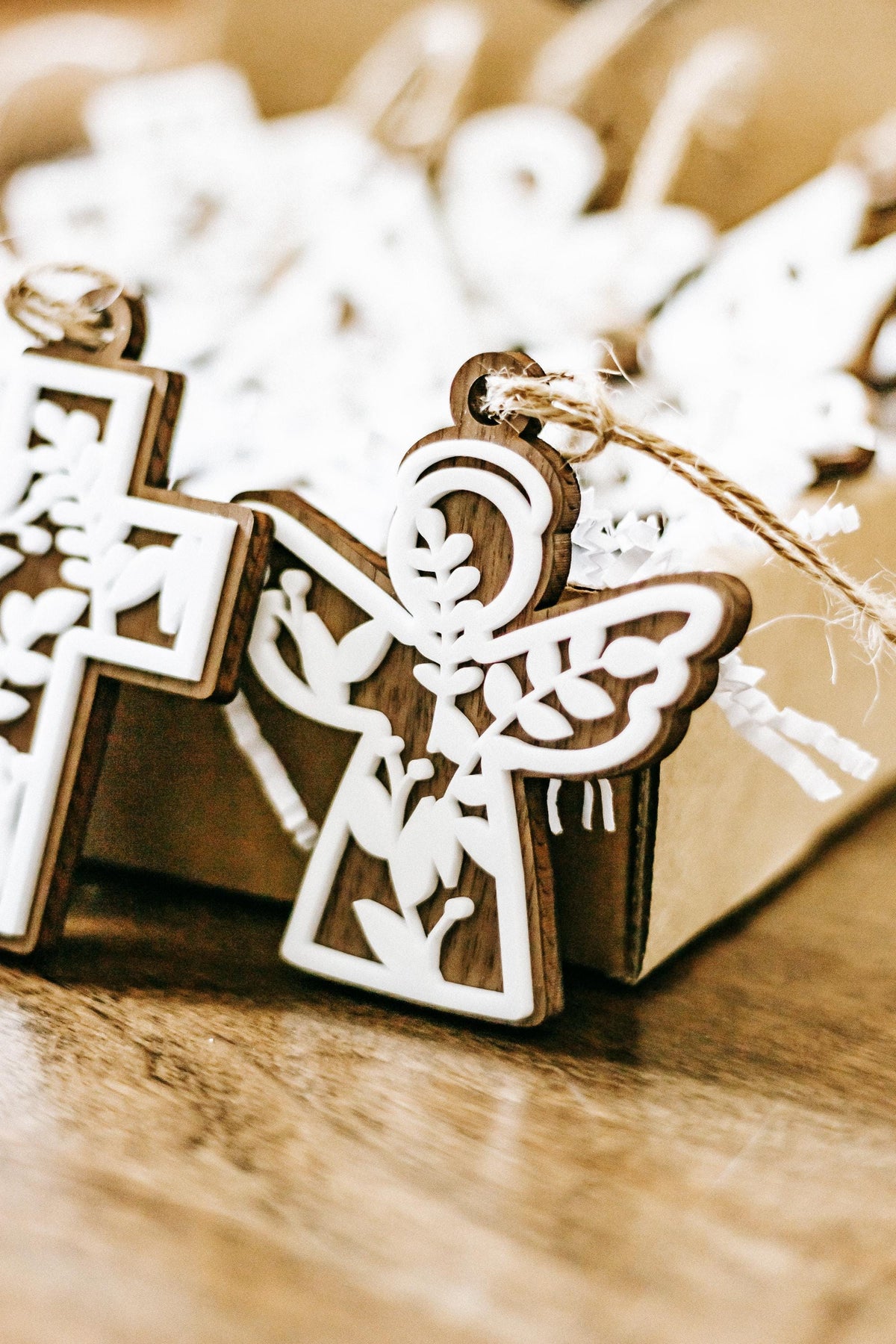 White floral cutout Christmas ornaments with wooden frames, cross and angel shapes, string hangers