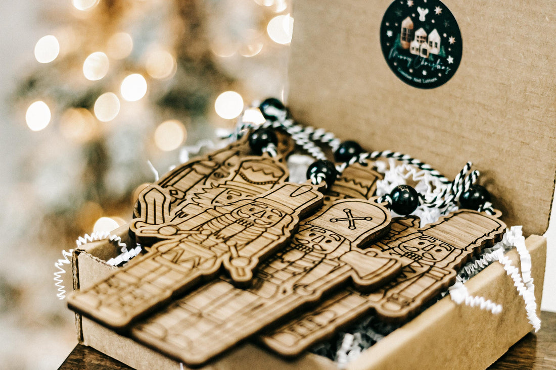 Set of 6 engraved wooden nutcracker ornaments laid in a gift box with bead cords