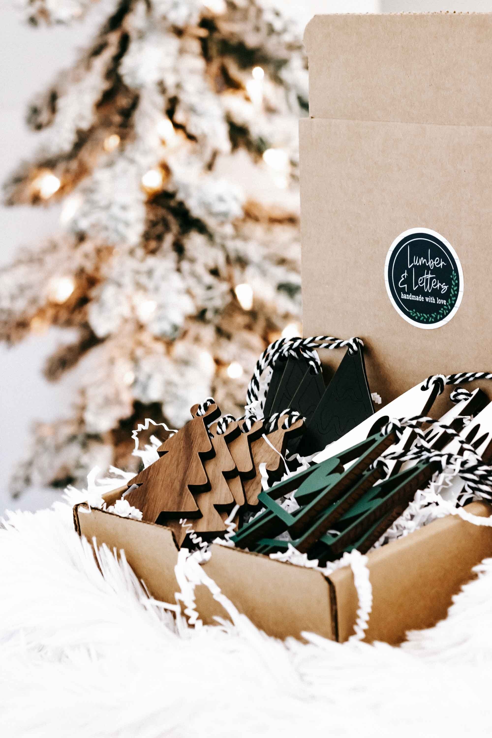 Cardboard box of wooden Christmas tree ornaments, natural wood and dark green with rope hangers