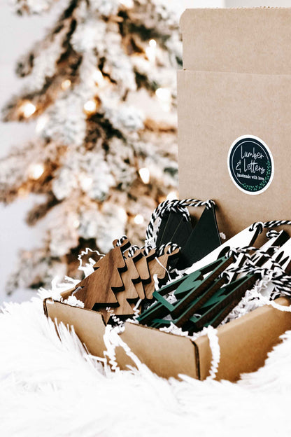 Cardboard box of wooden Christmas tree ornaments, natural wood and dark green with rope hangers