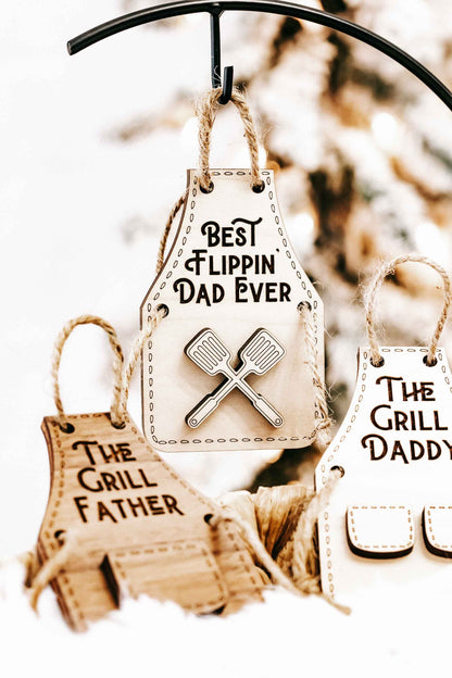 Wood ornaments: “Best Flippin’ Dad Ever” with crossed spatula design and “The Grill Father” behind.