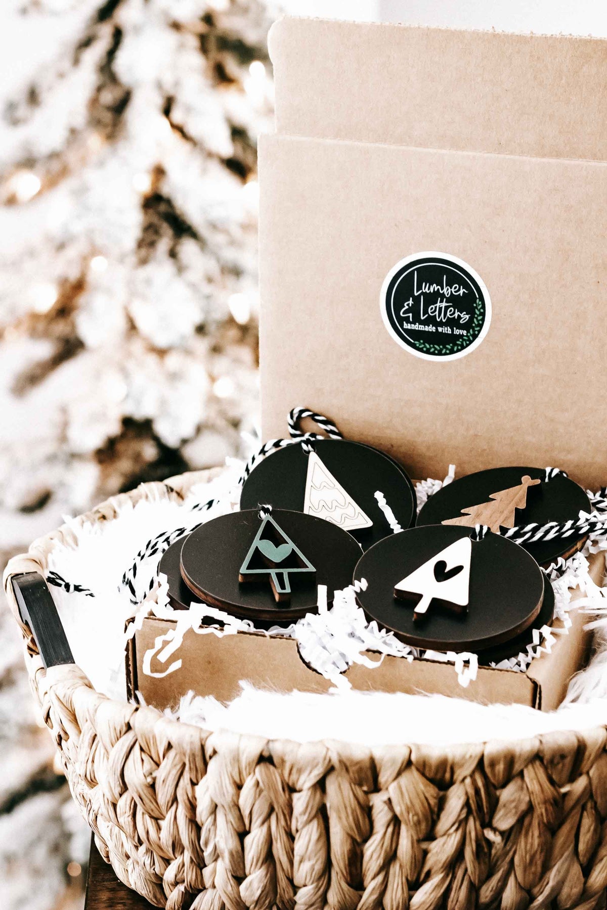 Kraft gift box with black round Christmas ornaments and twine hangers, tree and heart icons