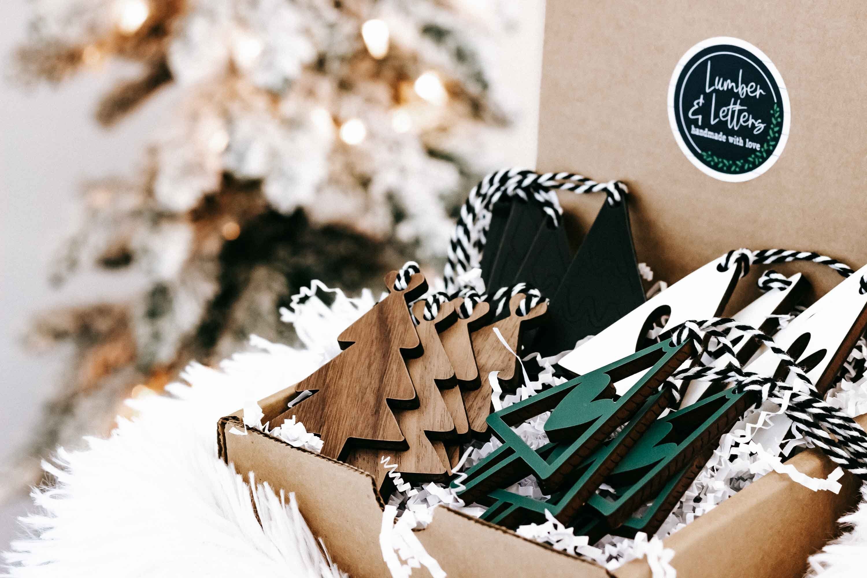 Cardboard box with assorted wooden Christmas ornaments in natural wood and dark green