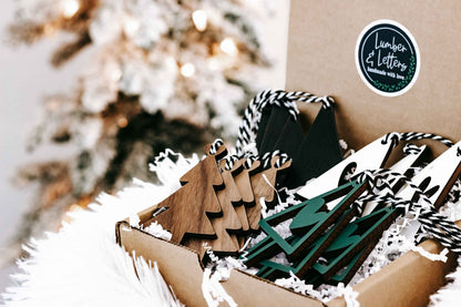 Cardboard box with assorted wooden Christmas ornaments in natural wood and dark green